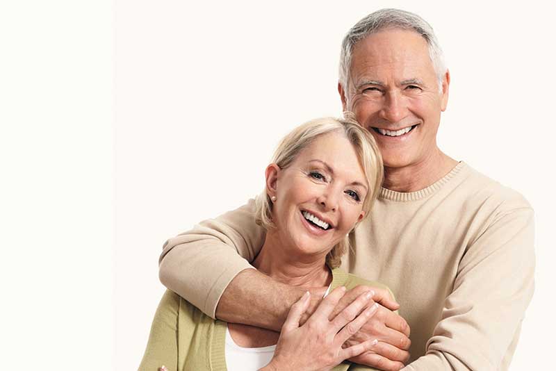 Portrait of cute Caucasian couple smiling together over white background